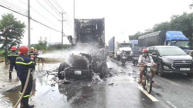 Lực lượng chữa cháy đã kịp thời dập tắt vụ cháy. (Ảnh: TTXVN phát) Cháy xe container trên Quốc lộ 1A, tài xế may mắn thoát nạn ảnh 1