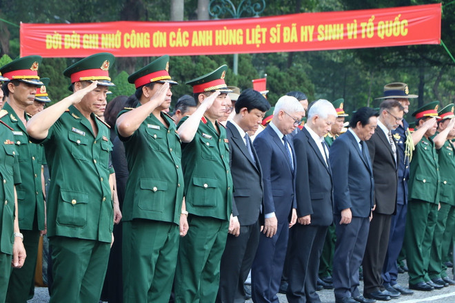 Các đại biểu dành phút mặc niệm các anh linh liệt sỹ. (Ảnh: Huyền Trang/TTXVN) vna_potal_le_truy_dieu_an_tang_hai_cot_cac_liet_si_quy_tap_tai_huyen_bac_tan_uyen_binh_duong_7344052_resize.jpg