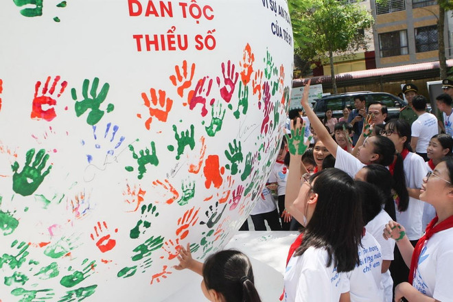 Các em học sinh in dấu tay lên quả cầu phát động Tháng hành động vì trẻ em. (Ảnh: Thanh Tùng/TTXVN) Phó Thủ tướng Vũ Đức Đam dự Lễ phát động Tháng hành động vì trẻ em ảnh 1