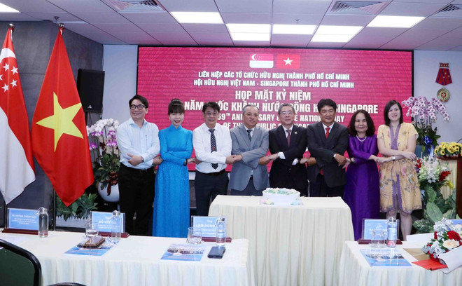 Các đại biểu thể hiện tình đoàn kết. (Ảnh: Xuân Khu/TTXVN) ttxvn_hop_mat_huu_nghi_ky_niem_59_nam_quoc_khanh_cong_hoa_singapore_2.jpg