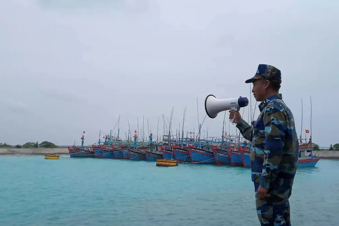 Lực lượng quân đội kêu gọi tàu thuyền tránh trú bão số 9 vào âu tàu của đảo Song Tử Tây, Trường Sa, Khánh Hòa. (Ảnh: TTXVN phát) Công điện của Thủ tướng Chính phủ về khẩn trương ứng phó bão số 9 ảnh 1