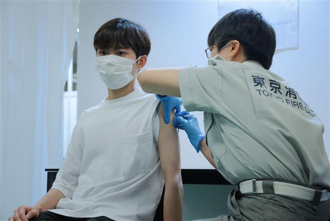 Tiêm vaccine ngừa COVID -19 tại Tokyo, Nhật Bản. (Ảnh: AFP/TTXVN) Nhật Bản vật lộn ngăn chặn Omicron, Ấn Độ bảo vệ thành quả chống dịch ảnh 1