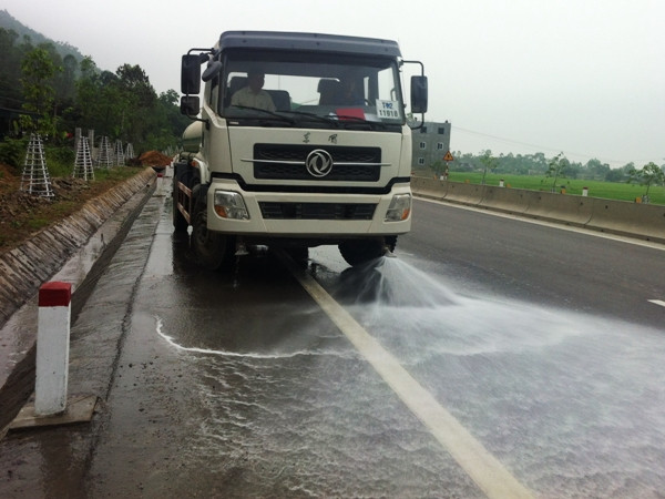 Xe tưới nước làm mát mặt đường và làm trôi bụi, đất đá rơi vãi. (Ảnh: Cienco 4 cung cấp) Quốc lộ 1 đoạn Vinh-Hà Tĩnh mới khánh thành đã bị lún vì xe quá tải ảnh 2