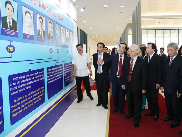 Tổng Bí thư Nguyễn Phú Trọng xem một số hình ảnh và sản phẩm được giới thiệu, trưng bày tại Lễ kỷ niệm. (Ảnh: Trí Dũng/TTXVN) Lễ kỷ niệm 60 năm Ngày truyền thống ngành Xây dựng Việt Nam ảnh 1