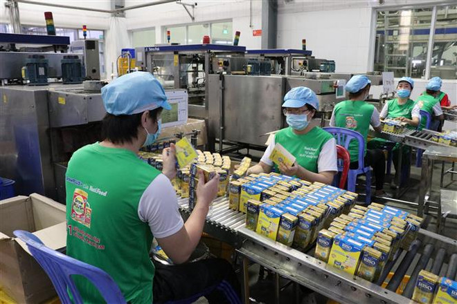 Hoạt động sản xuất tại Công ty Cổ phần thực phẩm dinh dưỡng Nutifood Bình Dương. (Ảnh: TTXVN) Chính phủ luôn đồng hành, hỗ trợ doanh nghiệp và người dân ảnh 1