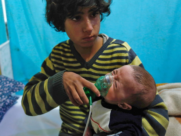 Trẻ em Syria phải sử dụng thiết bị cấp ôxy để thở sau một vụ tấn công bị nghi sử dụng khí độc tại Douma, Đông Ghouta ngày 22/1. (Nguồn: AFP/TTXVN) Syria: Chuyên gia của tổ chức OPCW đã đến thị trấn Douma ảnh 1