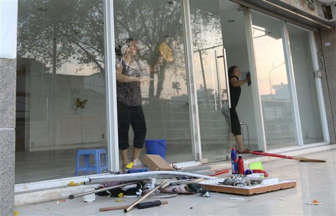 Cư dân block A, chung cư Carina Plaza trở về thu dọn để mở cửa lại quán cà phê Yuki ở tầng 1. (Ảnh: Thanh Vũ/TTXVN) Hơn 700 hộ gia đình đã về nơi ở sau vụ cháy chung cư Carina Plaza ảnh 1