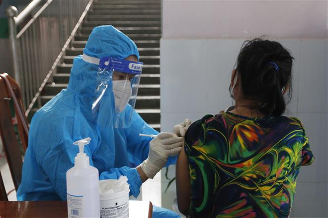 Tiêm vaccine phòng COVID-19 cho người dân tại Cà Mau. (Ảnh: Kim Há/TTXVN) Cà Mau: Số ca mắc giảm, nhiều địa phương trở lại vùng vàng, vùng xanh ảnh 1