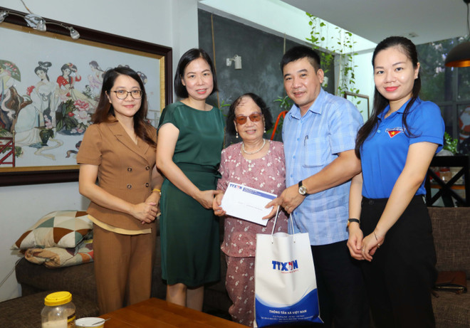 Tổng Giám đốc TTXVN Vũ Việt Trang thăm hỏi, tặng quà bà Phương Thị Bích Ngân, vợ liệt sỹ, nhà báo Thẩm Đức Hòa (huyện Gia Lâm, Hà Nội). (Ảnh: Hoàng Hiếu/TTXVN) Xúc động những lá thư tình thời chiến của nhà báo-liệt sỹ Thẩm Đức Hòa ảnh 1