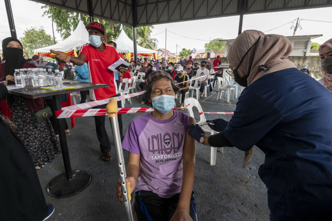 Nhân viên y tế tiêm vaccine ngừa COVID-19 cho người dân tại Kuala Lumpur, Malaysia. (Ảnh: THX/TTXVN) Dịch COVID-19: Malaysia đổi chiến lược về miễn dịch cộng đồng ảnh 1