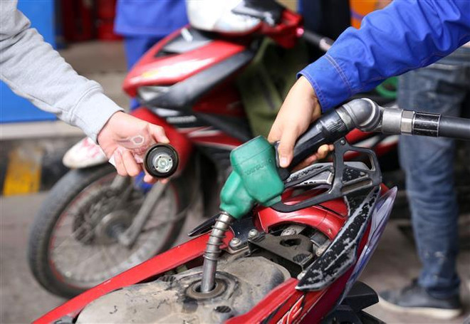 Đổ xăng cho khách hàng. (Ảnh: Huy Hùng/TTXVN) Đề xuất phạt 50 triệu đồng khi tự ý điều chỉnh giá bán lẻ xăng dầu ảnh 1
