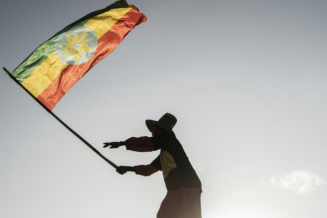 Một người dân cầm quốc kỳ của Ethiopia. (Nguồn: AFP) Đàm phán giữa Chính phủ Ethiopia và phiến quân diễn ra tại Nam Phi ảnh 1
