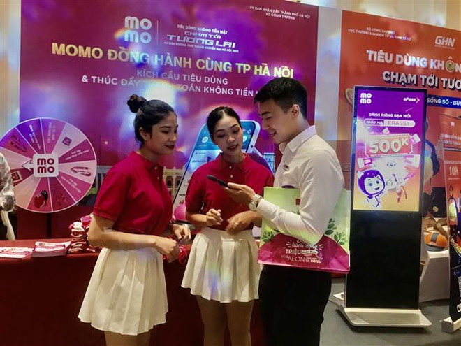 Người tiêu dùng hào hứng với ứng dụng thanh toán điện tử không dùng tiền mặt tại Sự kiện. (Ảnh: Phương Anh/TTXVN) Hà Nội: Tạo thói quen không dùng tiền mặt, thúc đẩy thương mại điện tử ảnh 1