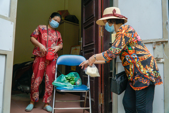 Bà Tuyết đi chợ hộ một người dân trong phường. (Ảnh: Minh Hiếu/Vietnam+) Lực lượng ‘bóng hồng’ trong công cuộc hỗ trợ phòng chống dịch COVID-19 ảnh 1