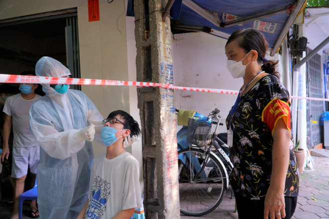 Bà Liên tham gia tổ công tác rà soát, xét nghiệm COVID-19 tới từng hộ dân. (Ảnh: Minh Hiếu/Vietnam+) Lực lượng ‘bóng hồng’ trong công cuộc hỗ trợ phòng chống dịch COVID-19 ảnh 2