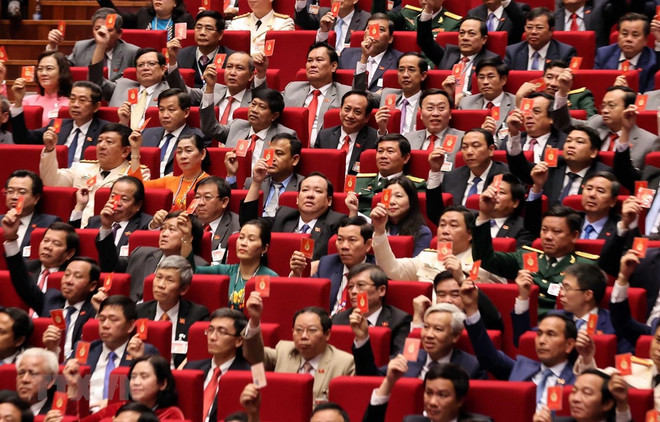Các đại biểu biểu quyết, thông qua Nghị quyết Đại hội XIII Đảng Cộng sản Việt Nam. (Ảnh: TTXVN) Đại hội Đảng XIII: Tầm nhìn và khát vọng hướng tới tương lai ảnh 1