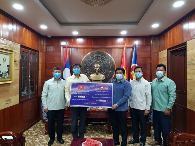 Đại diện chính quyền tỉnh Phongsaly, Lào trao tặng tiền hỗ trợ 6 tỉnh của Việt Nam ứng phó với đại dịch. (Ảnh: TTXVN phát) Các tỉnh của Lào hỗ trợ địa phương Việt Nam phòng chống dịch COVID-19 ảnh 1