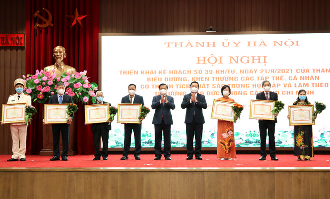 Bí thư Thành ủy Đinh Tiến Dũng và Trưởng Ban Tuyên giáo Trung ương Nguyễn Trọng Nghĩa trao Bằng khen của Thủ tướng Chính phủ cho các tập thể, cá nhân. (Nguồn: hanoi.gov.vn) Hà Nội: Tạo chuyển biến mạnh mẽ trong học và làm theo lời Bác ảnh 1