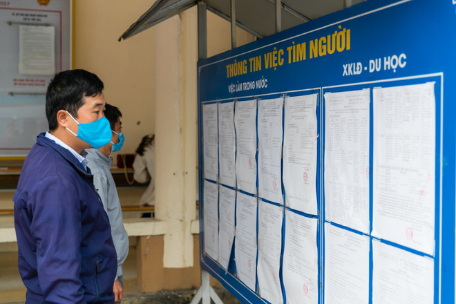 Người lao động tìm hiểu thông tin việc làm của các đơn vị tuyển dụng. (Ảnh: Bích Huệ/TTXVN) Nhiều cơ hội việc làm cho người lao động hồi hương tại Nghệ An ảnh 1