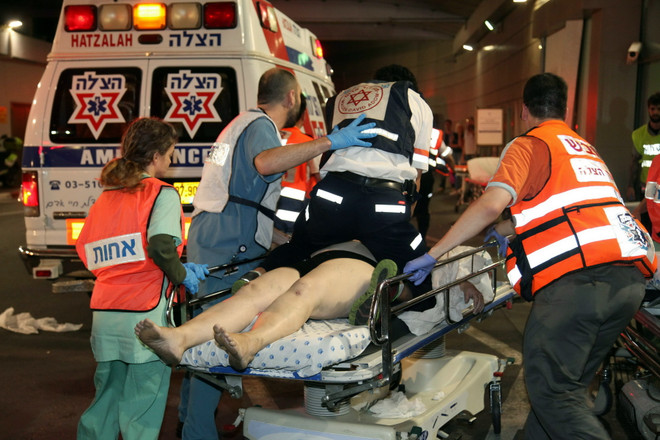 Nhân viên y tế Israel chuyển người bị thương tại hiện trường vụ tấn công tối 8/6. (Nguồn: AFP/TTXVN) Israel triển khai thêm hàng trăm binh sỹ ở Bờ Tây sau vụ xả súng ảnh 1