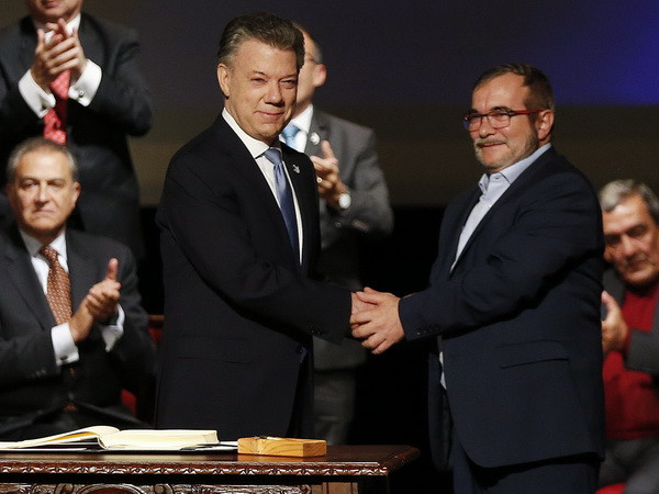 Tổng thống Colombia Juan Manuel Santos (trái, trước) và Thủ lĩnh tối cao FARC Rodrigo Londono Echeverri sau lễ ký Thỏa thuận hòa bình sửa đổi ở Bogota ngày 24/11. (Nguồn: AP/TTXVN) Quốc hội Colombia bắt đầu xem xét thông qua Luật Ân xá ảnh 1