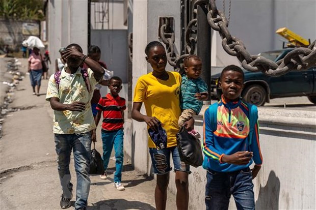 Người dân rời bỏ nhà cửa sau cuộc tấn công của bang nhóm tội phạm tại Port-au-Prince, Haiti. (Ảnh: AFP/TTXVN) Thiếu kinh phí hỗ trợ, WFP thông báo cắt giảm viện trợ cho Haiti ảnh 1