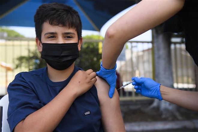 Tiêm vaccine ngừa COVID-19 của Hãng Pfizer cho trẻ em 13 tuổi tại Los Angeles, California (Mỹ) ngày 14/5. (Ảnh: AFP/TTXVN) Anh nghiên cứu thử nghiệm tiêm kết hợp vaccine COVID-19 cho trẻ em ảnh 1