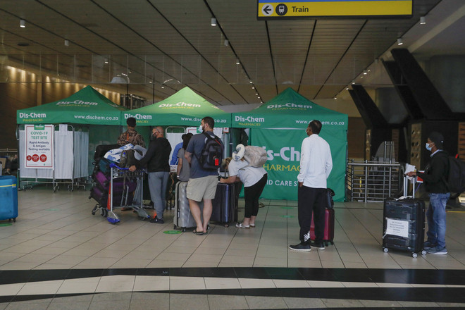 Hành khách xếp hàng chờ xét nghiệm COVID-19 tại sân bay ở Johannesburg, Nam Phi, ngày 27/11/2021. (Ảnh: AFP/TTXVN) G7 yêu cầu hành động khẩn cấp nhằm đối phó với biến thể Omicron ảnh 1