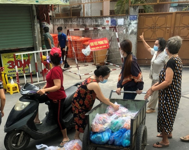 Các tổ chức, đoàn thể cung cấp nhu yếu phẩm cho người dân trong khu vực cách ly tại hẻm 637/37 Quang Trung, quận Gò Vấp, Tp.Hồ Chí Minh. (Ảnh: Anh Tuấn/TTXVN) Tiếp tục các hoạt động ủng hộ hoạt động phòng, chống dịch COVID-19 ảnh 1