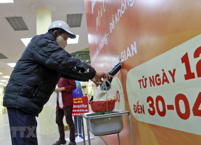 Người nghèo, người có hoàn cảnh khó khăn nhận gạo miễn phí từ cây ATM gạo đặt tại phường Phúc Diễn, quận Bắc Từ Liêm, Hà Nội. (Ảnh: TTXVN) "Việt Nam nổi lên như hình mẫu thành công chống dịch của thế giới" ảnh 1