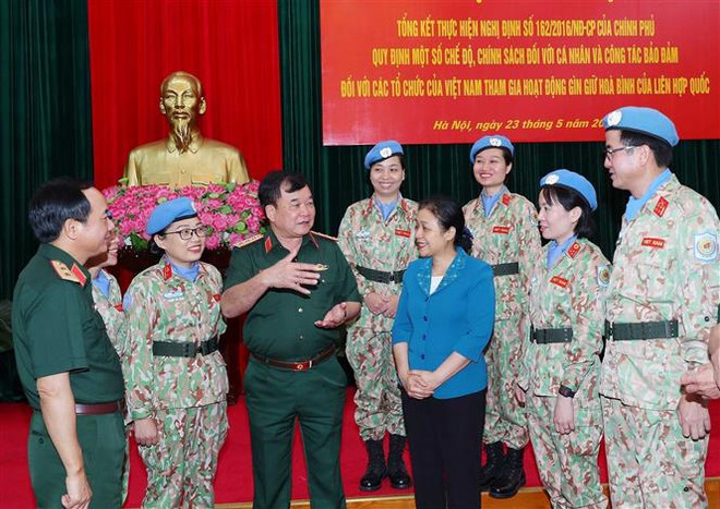 Thượng tướng Hoàng Xuân Chiến, Ủy viên Trung ương Đảng, Thứ trưởng Bộ Quốc phòng và các đại biểu trao đổi bên lề hội nghị. (Ảnh: Trọng Đức/TTXVN) Đảm bảo chế độ, chính sách với đối tượng tham gia Gìn giữ Hòa bình ảnh 3