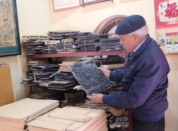 Nghệ nhân Nguyễn Đăng Chế giới thiệu bản khắc cổ của dòng tranh dân gian Đông Hồ. (Ảnh: TTXVN) Hoàn thiện hồ sơ tranh dân gian Đông Hồ đệ trình UNESCO ảnh 1