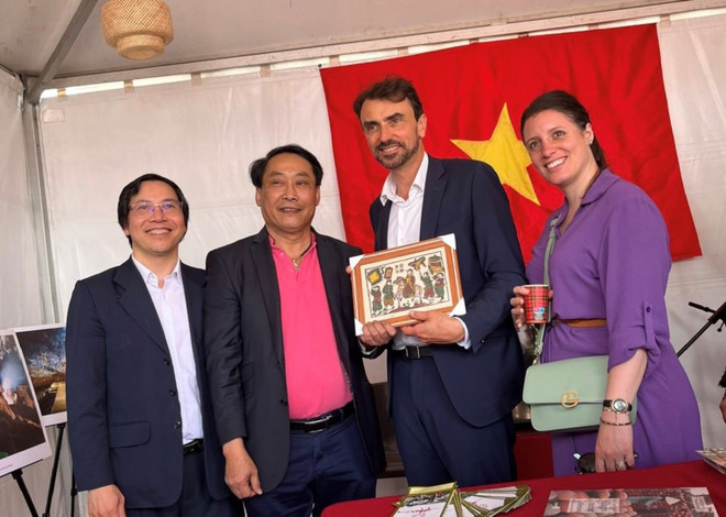 Thị trưởng thành phố Lyon, ông Grégory Doucet tham quan Không gian Việt Nam và rất ấn tượng với nét độc đáo của tranh Đông Hồ. (Ảnh : TTXVN phát) ttxvn_ao_dai_1706-2.jpg