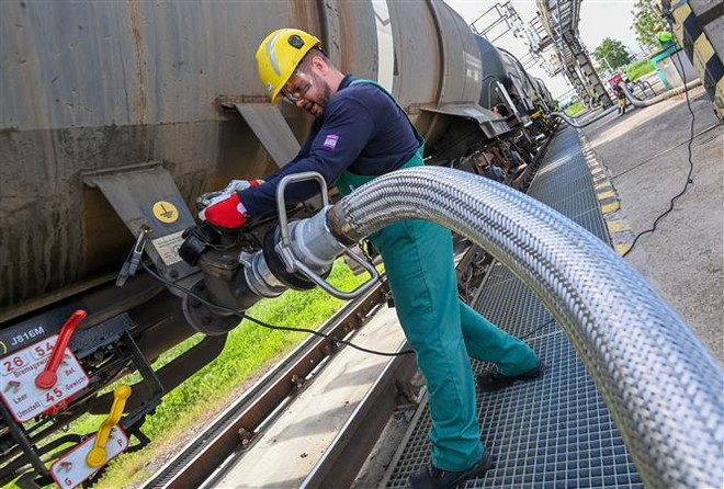 Công nhân vận hành ống dẫn nhiên liệu lỏng tại cơ sở lọc dầu ở thị trấn Szazhalombatta, Hungary. (Ảnh: AFP/TTXVN) EU công bố thời điểm kế hoạch cắt giảm tiêu thụ khí đốt có hiệu lực ảnh 1