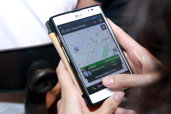 Dùng GrabTaxi để gọi taxi đến đón. (Ảnh: T.Nguyên/Vietnam+) Cho phép đặt taxi bằng vài cú click trên điện thoại di động ảnh 1