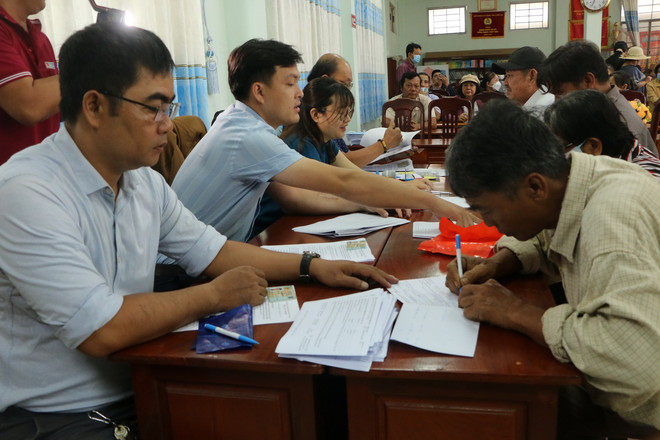 Cán bộ xã Tân Bửu, huyện Bến Lức, tỉnh Long An, hướng dẫn thủ tục người dân nhận tiền đền bù giải phóng mặt bằng. (Ảnh: Thanh Bình/TTXVN) vanh_dai_3_thanh_pho_ho_chi_minh2.jpg