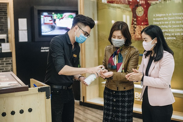 Nhân viên một nhà hàng đang hướng dẫn khách rửa tay sạch trước khi dùng bữa. (Nguồn: Vietnam+) COVID-19: Người dân bình tĩnh quay trở lại nhịp sống bình thường ảnh 9