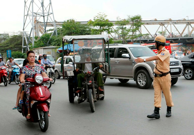 Cảnh sát giao thông Đội 1, Phòng Cảnh sát giao thông Hà Nội kiểm tra, xử lý xe thương binh giả. (Ảnh: Doãn Tấn/TTXVN) Hà Nội quyết liệt xử lý các xe thương binh giả vi phạm pháp luật ảnh 1
