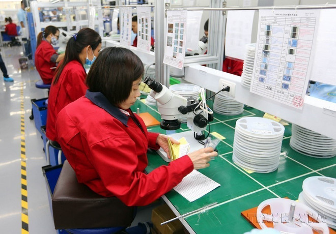 Lao động khuyết tật làm việc tại xưởng sản xuất cùng với những người lao động bình thường khác tại Công ty trách nhiệm hữu hạn Điện tử Chilisin Việt Nam. (Ảnh: Danh Lam/TTXVN) TTXVN_1504khuyettat2.jpg
