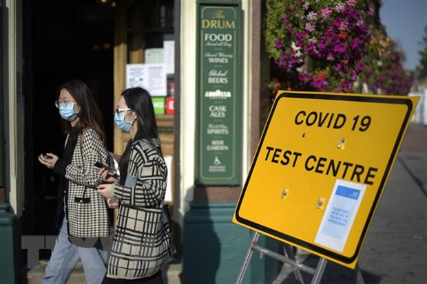 Người dân đeo khẩu trang phòng lây nhiễm COVID-19 tại London, Anh. (Nguồn: AFP/TTXVN) Anh siết chặt hạn chế, Italy ghi nhận số ca mắc COVID-19 mới tăng mạnh ảnh 1