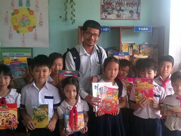 Ông Nguyễn Quang Thạch và các em nhỏ bên những cuốn sách từ chương trình "Sách hóa nông thôn." (Nguồn: Vietnam+) "Sách hóa nông thôn" của Việt Nam được UNESCO vinh danh ảnh 1