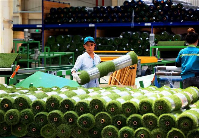 Sản xuất thảm cỏ nhân tạo tại Công ty TNHH CCGrass Việt Nam, khu công nghiệp Phước Đông, huyện Gò Dầu, Tây Ninh. (Ảnh: Hồng Đạt/TTXVN) Bàn giải pháp tăng trưởng kinh tế các nước ASEAN sau dịch COVID-19 ảnh 1