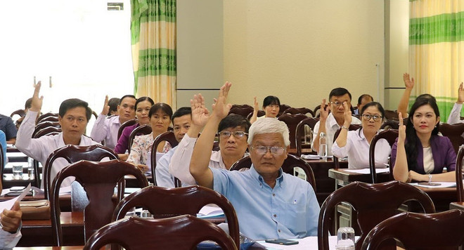 Các đại biểu biểu quyết thống nhất danh sách những người đủ tiêu chuẩn ứng cử. (Ảnh: Hữu Chí/TTXVN) Bầu cử QH và HĐND: Các địa phương thống nhất danh sách người ứng cử ảnh 1