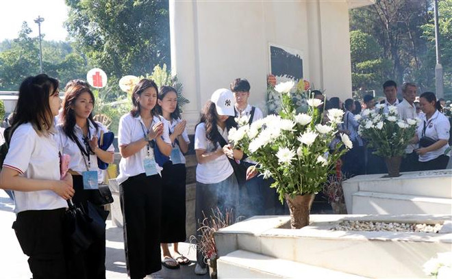 Thanh niên, sinh viên Kiều bào dâng hương tại mộ 10 Nữ Anh hùng Liệt sỹ Thanh niên Xung phong. (Ảnh: Công Tường/TTXVN) 120 Kiều bào Trẻ dâng hương tưởng niệm tại Ngã ba Đồng Lộc ảnh 1