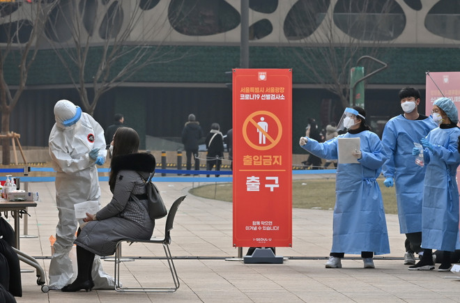 Nhân viên y tế lấy mẫu xét nghiệm COVID-19 cho người dân tại Seoul, Hàn Quốc. (Ảnh: AFP/TTXVN) COVID-19: Nhật Bản vượt ngưỡng 400.000, Hàn Quốc vượt mốc 80.000 người ảnh 2