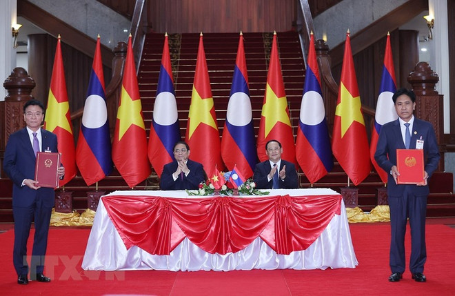 Thủ tướng Phạm Minh Chính và Thủ tướng Lào Sonexay Siphandone chứng kiến lễ ký Hiệp định tương trợ tư pháp dân sự giữa Việt Nam và Lào. (Ảnh: Dương Giang/TTXVN) Báo Lào đưa tin chào mừng chuyến thăm của Thủ tướng Phạm Minh Chính ảnh 2