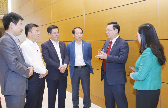 Chủ tịch Quốc hội Vương Đình Huệ trao đổi với các đại biểu. (Ảnh: Doãn Tấn/TTXVN) Sửa đổi luật về bảo hiểm cần bảo đảm cân bằng lợi ích bên bán và mua ảnh 2