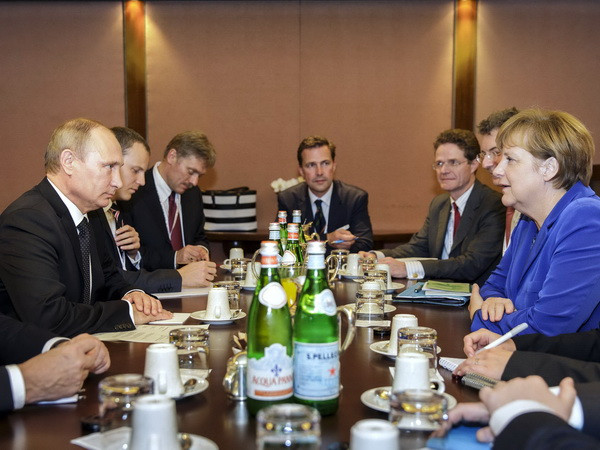 Tổng thống Nga Vladimir Putin (trái) và Thủ tướng Đức Angela Merkel (phải) trong cuộc gặp song phương bên lề Hội nghị thượng đỉnh Á-Âu (ASEM) lần thứ 10. (Nguồn: AFP/TTXVN) Ông Putin và bà Merkel điện đàm về tình hình Ukraine ảnh 1