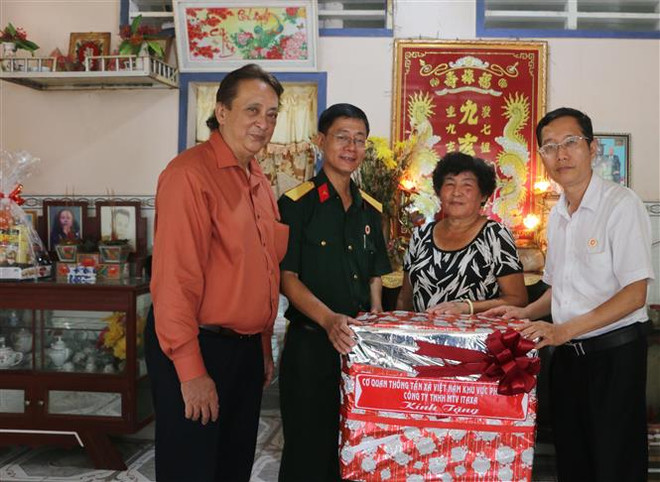 Phó Giám đốc Cơ quan TTXVN khu vực phía Nam Trần Tràng Dương (thứ 2 trái qua) và Chủ tịch Hội đồng thành viên Công ty TNHH MTV ITAX Nguyễn Châu Phúc) (bìa phải) tặng quà cho thân nhân liệt sỹ Lê Văn Tròn ở ấp Long Hòa 1, xã Long Hòa, huyện Phú Tân, tỉnh An Giang. (Ảnh: Công Mạo/TTXVN) Thông tấn xã Việt Nam tri ân các thương binh, liệt sĩ tại An Giang ảnh 1
