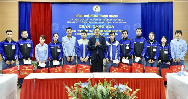 Chủ tịch Liên đoàn Lao động thành phố Hà Nội Phạm Quang Thanh tặng quà Tết cho công nhân Công ty TNHH Sản xuất phụ tùng Yamaha Motor Việt Nam. (Ảnh: Minh Nghĩa/TTXVN) TTXVN_2807congdoan1.jpg